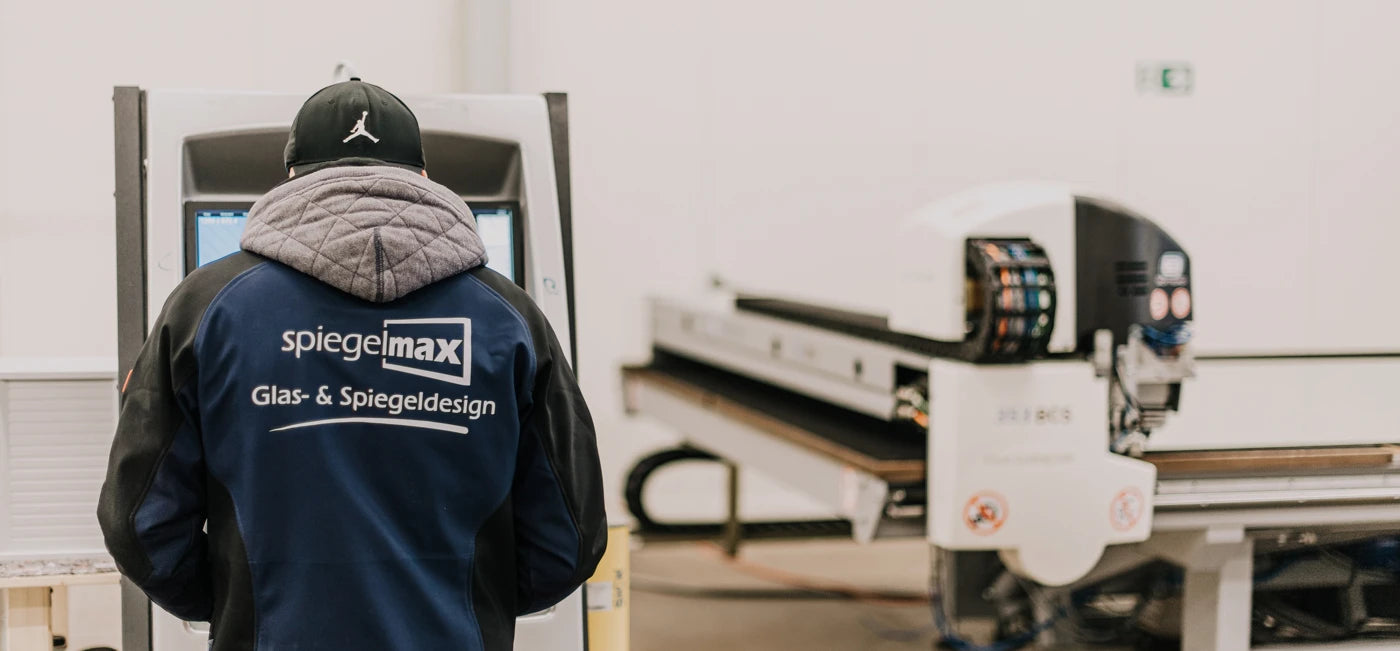 Spiegelmax Mitarbeiter bedient CNC-Anlage – präziser Zuschnitt und Kantenbearbeitung