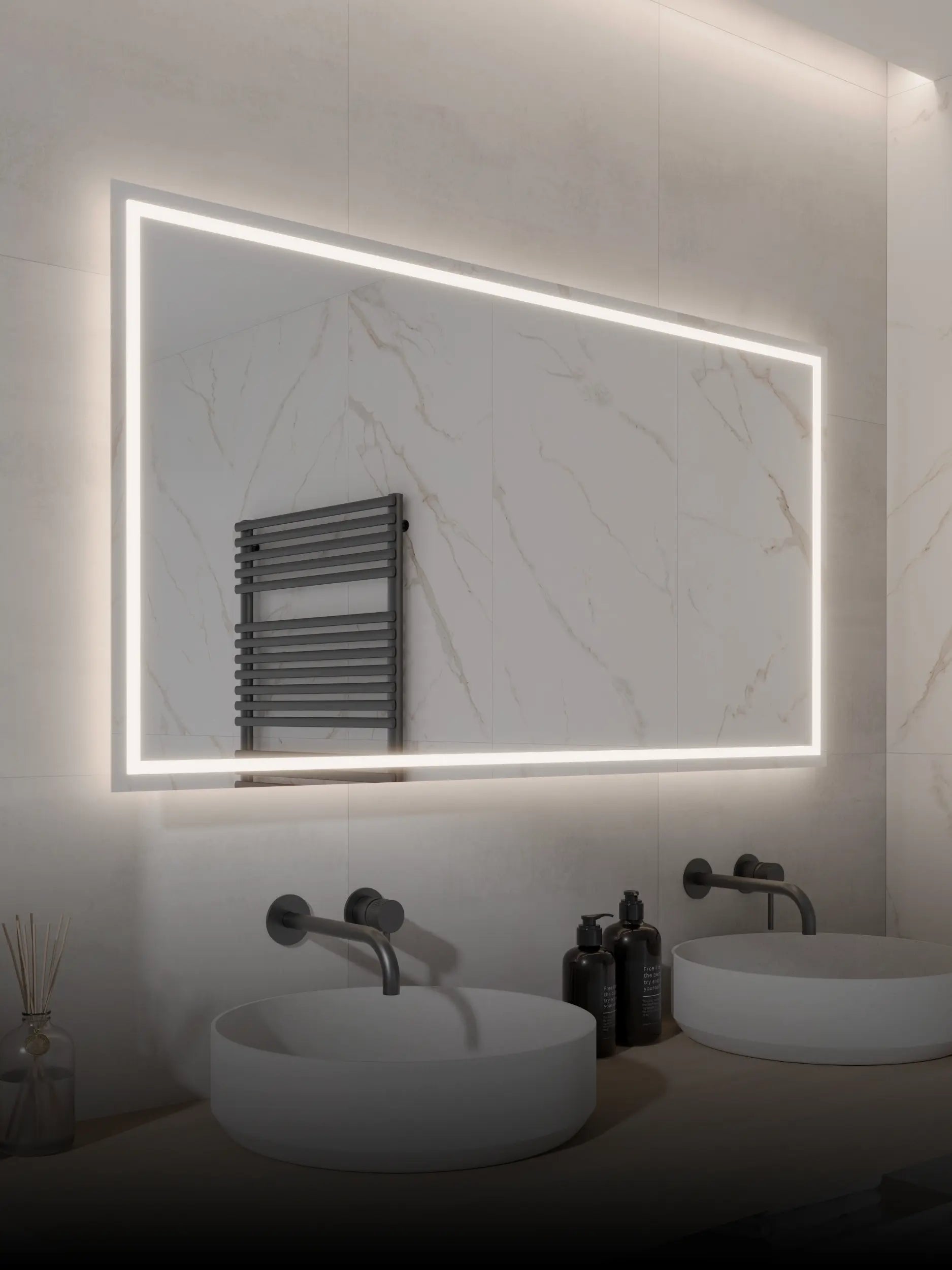 Beleuchteter rechteckiger Wandspiegel über zwei runden weißen Waschbecken mit schwarzen Armaturen in einem modernen Badezimmer mit Marmorfliesen.
