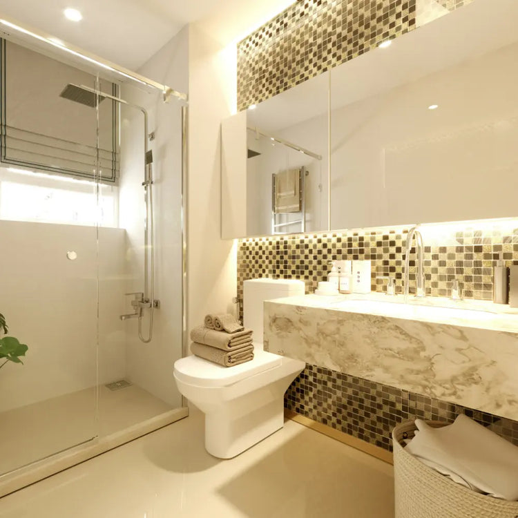 Badezimmer mit Glas-Duschwand, großem Wandspiegel, Waschtisch aus Marmor und goldener Mosaikfliese an der Wand.