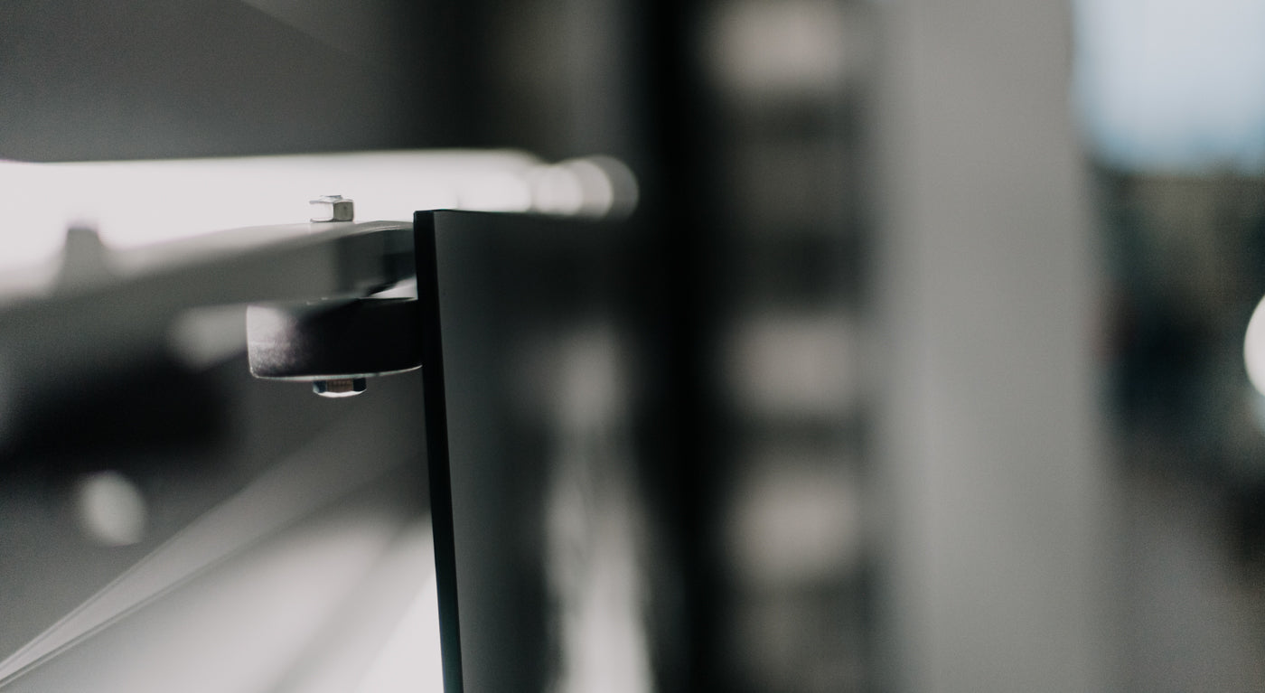 Detailaufnahme einer hochwertigen Glashalterung mit Metallbefestigung in moderner Optik