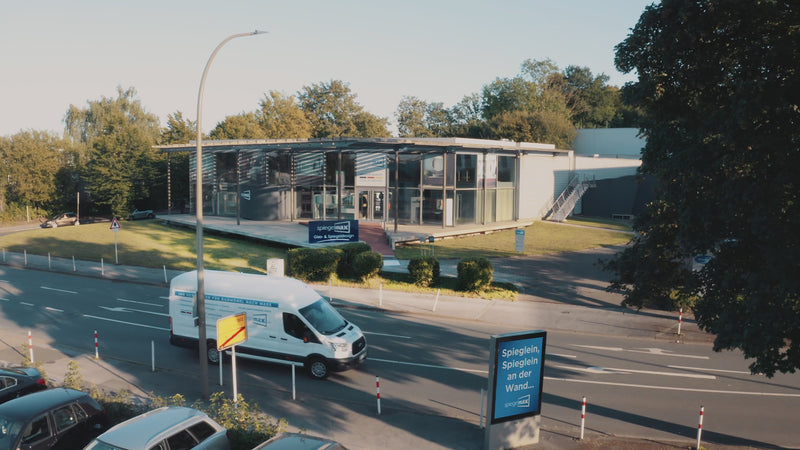 Video über Spiegelmax in Dortmund: LED-Spiegel im Showroom, CNC-Fertigung, großer Schneidtisch und Team beim Handling von Spiegelglas.